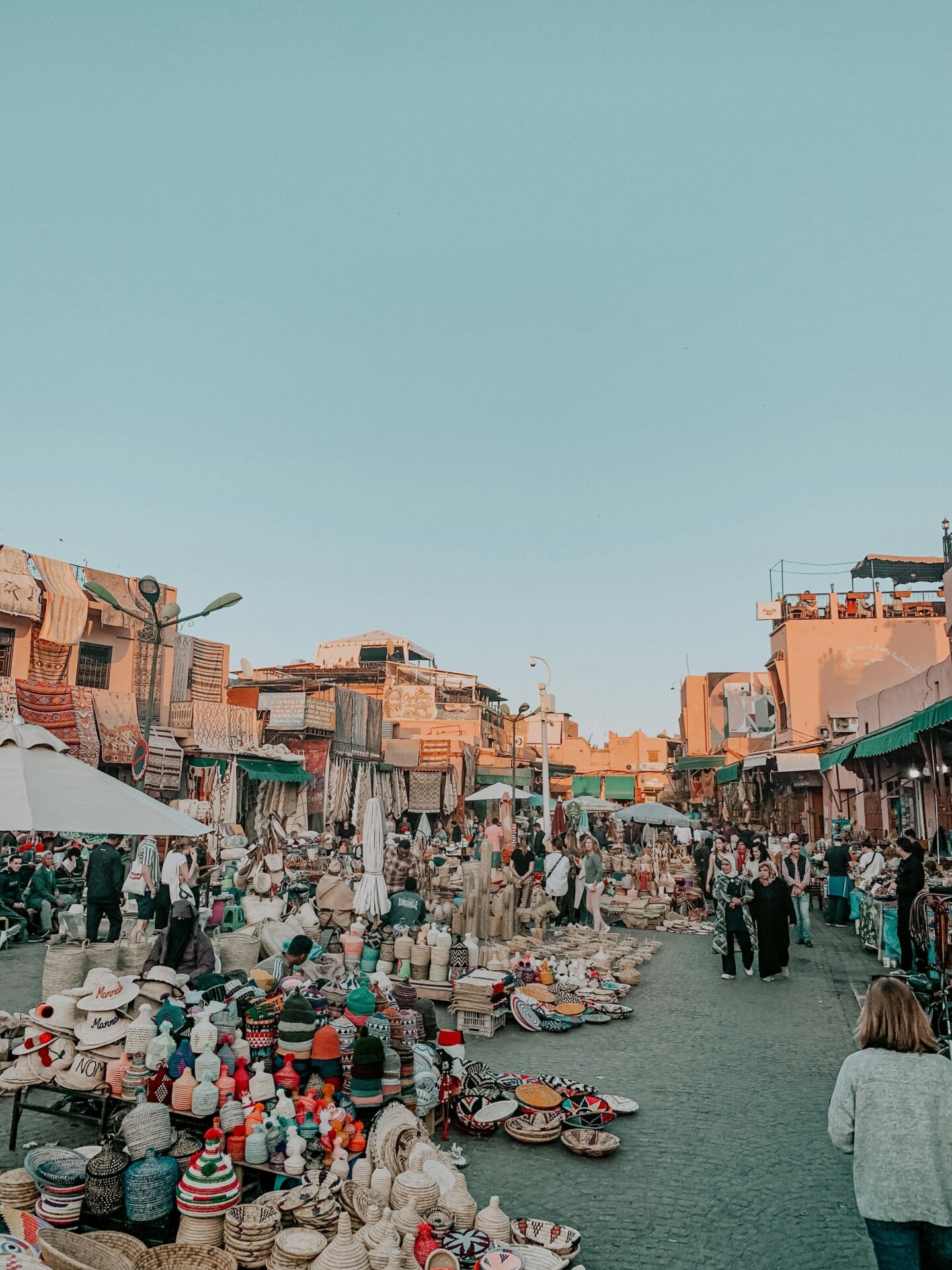Vibrant view of Jemaa el-Fnaa square in Marrakech with street performers, market stalls, and traditional Moroccan atmosphere.