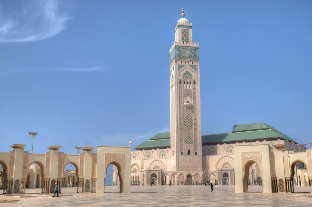 Hassan II Mosque in Casablanca, overlooking the Atlantic Ocean under a clear sky.