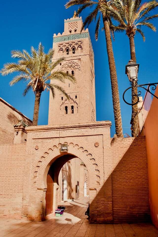 Koutoubia Mosque in Marrakech, Morocco – iconic 12th-century minaret surrounded by gardens and palm trees under a clear sky